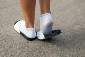 uma mulher com branco meias e sandálias dentro verão foto