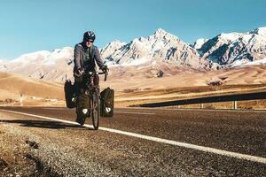 masculino caucasiano ciclista ciclo em asfalto rodovia estrada dentro Peru montanhas.neve picos ao ar livre foto