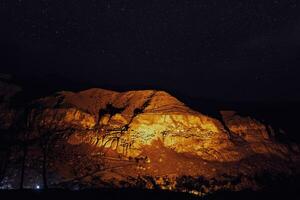 estrelado noite dentro famoso turista destino dentro iluminado pela Geórgia vardzia caverna cidade. romântico tarde dentro região selvagem debaixo a estrelas. foto