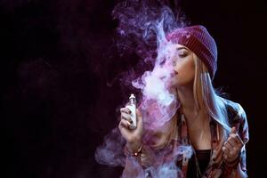 jovem mulher fumando cigarro eletrônico foto