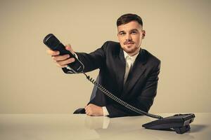 retrato do atraente homem de negocios segurando Telefone dentro dele mão foto