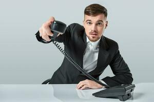 retrato do atraente homem de negocios segurando Telefone dentro dele mão. isto ligar é para você conceito foto