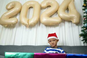 alegre Natal 2024 conceito uma Garoto segurando uma presente caixa é feliz para receber uma presente em Natal dia. foto