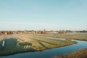 popular turista local Zaanse Schans é perto amsterdam dentro a oeste do a Holanda. histórico, realista moinhos de vento durante nascer do sol. Holanda ponto de referência foto