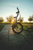 equitação a elétrico bicicleta durante pôr do sol em a subúrbios do Amsterdã, a capital do a Holanda. uma lazer atividade foto