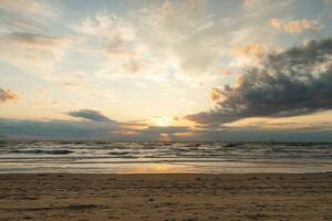 tirar o fôlego pôr do sol em a margens do a norte mar perto Zandvoort, Holanda. abstrato Visão do a mar superfície e a colorida céu foto