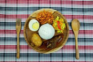 vermelho temperado frango arroz com em conserva pepino e cenouras, fervido ovo, batata bolinhos e doce temperado frito batatas. foto