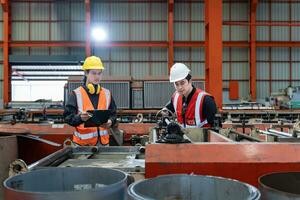 equipe do ásia industrial trabalhador é verificação configuração valor do a metal Folha lista formando máquina de automatizado monitor enquanto trabalhando dentro cobertura fábrica para segurança indústria foto