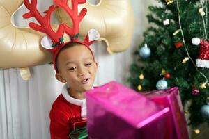 alegre Natal 2024 conceito Garoto recebe uma presente a partir de dele mãe às Natal foto