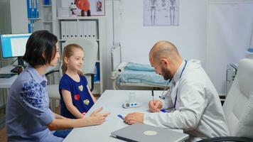 médico mudando a criança tratamento depois de a consulta. cuidados de saúde médico especialista dentro remédio fornecendo saúde Cuidado Serviços consulta radiográfico tratamento exame dentro hospital gabinete foto