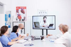 Videoconferência do hospital equipe com especialista doutor. remédio funcionários usando Internet durante conectados encontro com terapeuta médico para perícia. foto