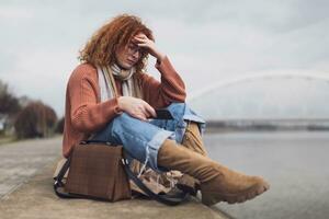 natural retrato do uma caucasiano gengibre mulher com sardas e encaracolado cabelo. ela é cansado e depressivo. foto