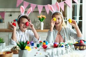 duas crianças se divertindo brincando com os olhos fechados com um ovo de Páscoa. foto