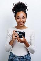 garota feliz tem uma câmera retro na mão. foto