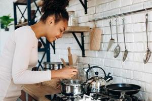 linda jovem dona de casa na cozinha foto