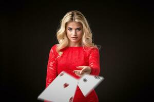 jovem lindo emocional mulher lança cartões em uma Preto fundo dentro a estúdio. pôquer foto