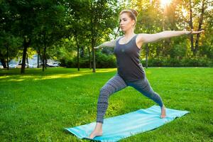 jovem mulher fazendo ioga exercícios dentro a verão cidade parque. foto