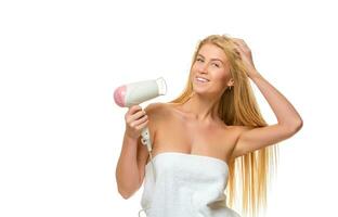 jovem mulher dentro toalha seca cabelo uma secador de cabelo foto