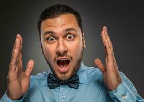 retrato jovem homem dentro azul camisa, olhando com espanto foto