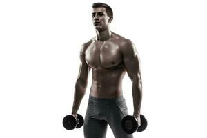 muscular homem mostrando perfeito corpo com halteres, isolado em branco foto