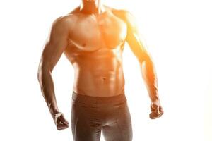 fisiculturista homem posando, mostrando perfeito abdômen, ombros, bíceps, tríceps, peito foto