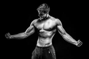 deslumbrante muscular homem mostrando perfeito abdômen, ombros, bíceps, tr foto