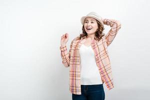 garota turista sorridente segurando o chapéu com a mão. foto