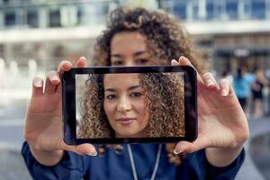 bonita jovem mulher levar uma selfie com inteligente telefone foto