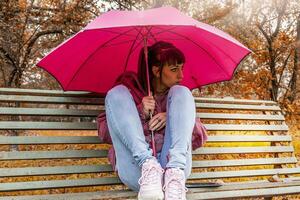 jovem mulher abrigo a partir de a outono chuva foto