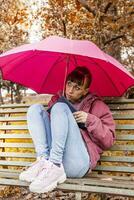 jovem mulher abrigo a partir de a outono chuva foto