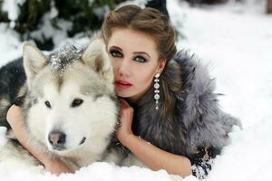 jovem mulher com Lobo cachorro dentro neve foto