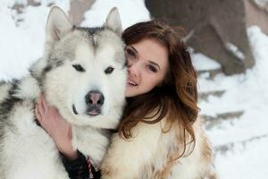 jovem mulher com Lobo cachorro dentro neve foto