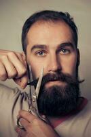homem corte barba contra uma cinzento fundo foto