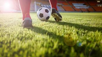 jogador de futebol ou futebol americano em pé com a bola no campo para chutar a bola no estádio de futebol foto