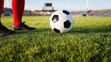 jogador de futebol ou futebol americano em pé com a bola no campo para chutar a bola no estádio de futebol
