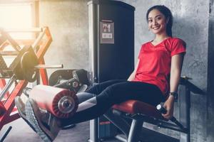 linda musculoso apto mulher exercitando construção de músculos e fitness mulher fazendo exercícios no ginásio. fitness - conceito de estilo de vida saudável foto