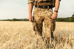 soldado homem em pé contra uma campo foto