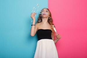 lindo jovem mulher com Sabonete bolhas sobre ciano fundo foto