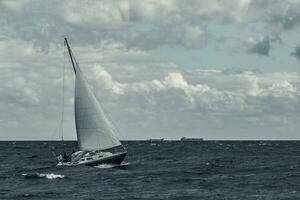 azul barco a vela dentro uma viagem às tormentoso mar. regata jornada. tonificado foto