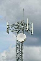 uma célula telefone torre com uma satélite prato em topo foto