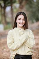 linda mulher asiática sorrindo, garota feliz e vestindo roupas quentes, inverno e outono retrato ao ar livre no parque foto