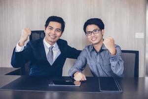 sucesso e conceito vencedor de empresários asiáticos - equipe feliz com as mãos levantadas celebrando o avanço e as conquistas foto