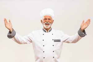imagem do Senior chefe de cozinha gesticulando em cinzento fundo. foto