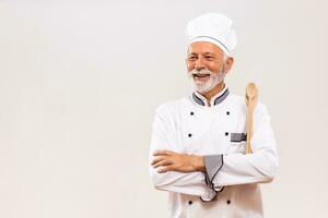 retrato do Senior chefe de cozinha com trabalhos ferramenta em cinzento fundo. foto