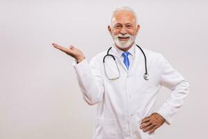 retrato do Senior médico gesticulando em cinzento fundo. foto