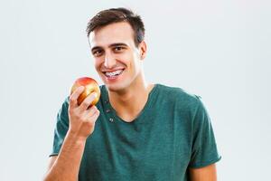 homem com suspensórios comendo maçã foto