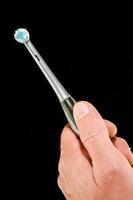 uma pessoa segurando uma escova de dente com uma azul dente foto