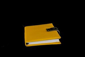 uma amarelo caderno com uma Preto cobrir foto