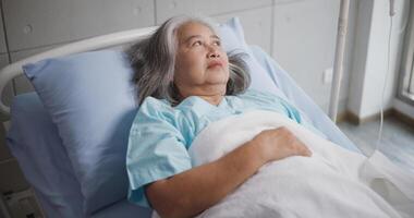 retrato do idosos fêmea paciente passando por tratamento deitado em uma hospital cama. foto