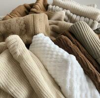 ai gerado muitos diferente tipos do tricotado vestuário estão empilhado junto, Eu foto